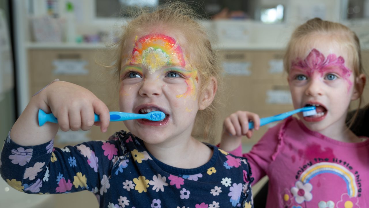 Two children brushing their teeth as part of the Smile Friendly oral health program