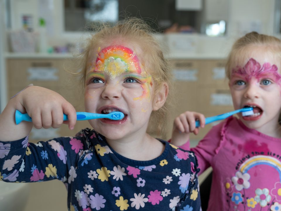 Two children brushing their teeth as part of the Smile Friendly oral health program