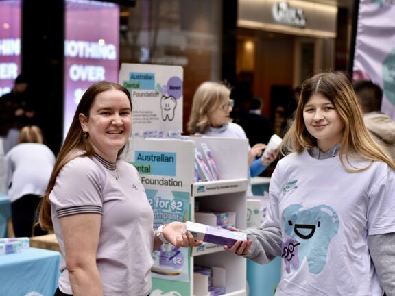 Australian Dental Foundation Volunteer handing out free toothpaste.