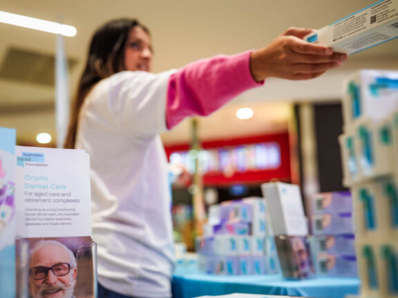 Australian Dental Foundation volunteer giving away free toothpaste.